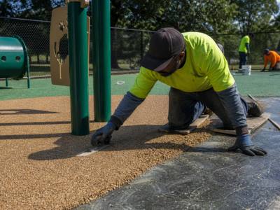 Tan rubber surfacing going in at a dog park